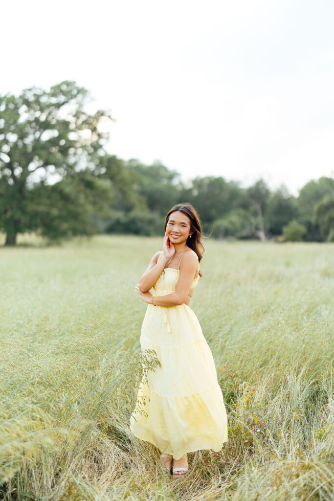 stunning senior wearing a flowy yellow dress for her photoshoot