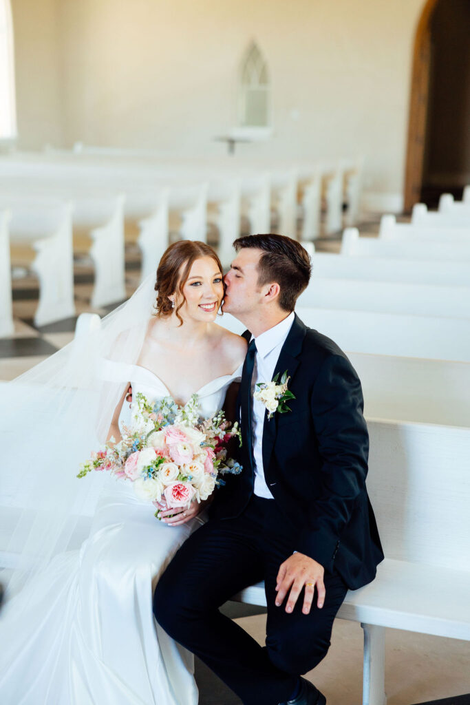 groom kissing the bride on the cheek