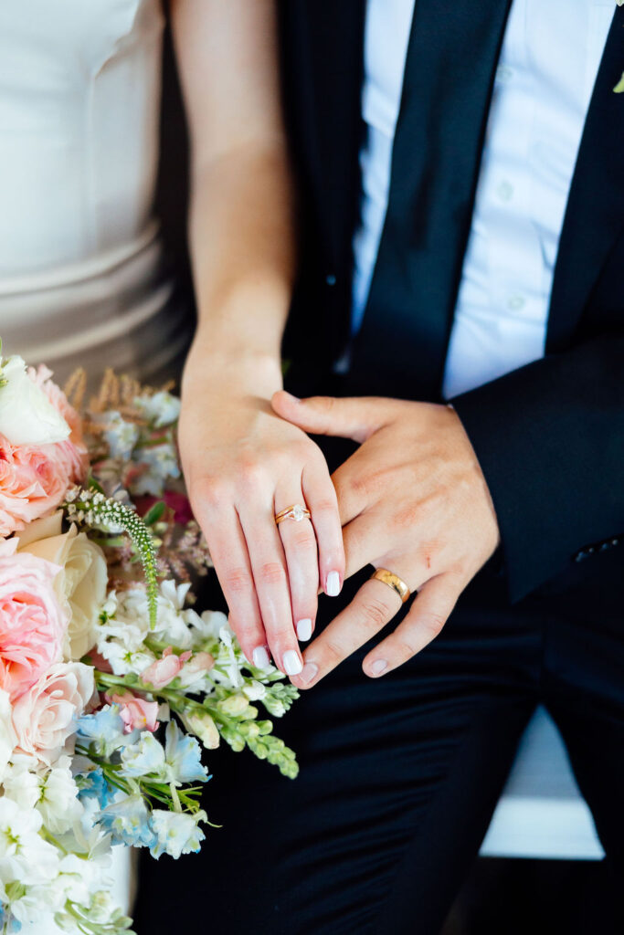 bride and groom showing their wedding rings 