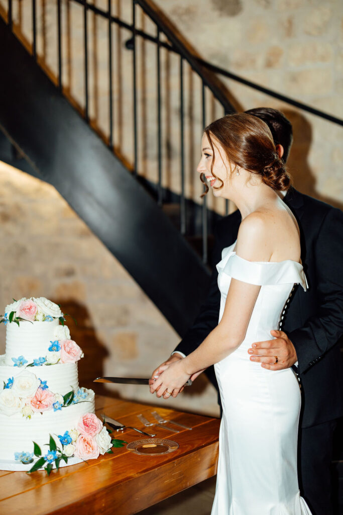 bride and groom cutting their wedding cake 