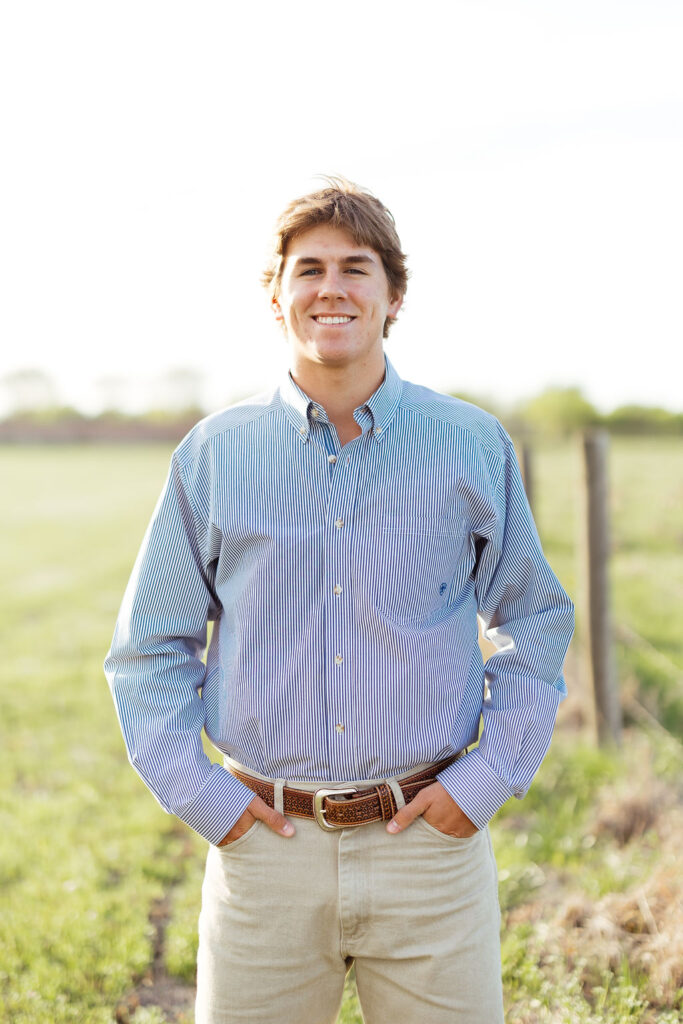 guy getting photos taken for his graduation in an open field