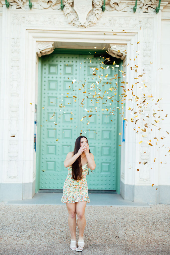 girl taking photos for college graduation with confetti