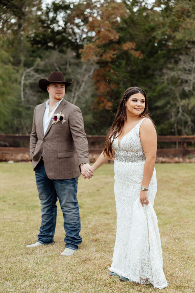 bride and groom holding hand during western wedding day at peach creek ranch in college station, texas